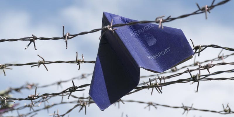 refugee passport stuck in barbed wire