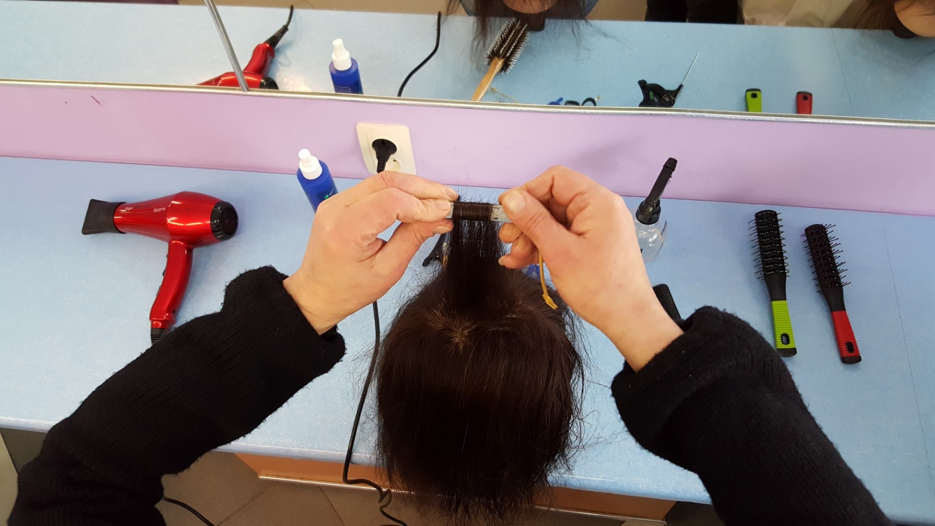 Woman learns to style hair as part of the NOVA Project woman styling hair