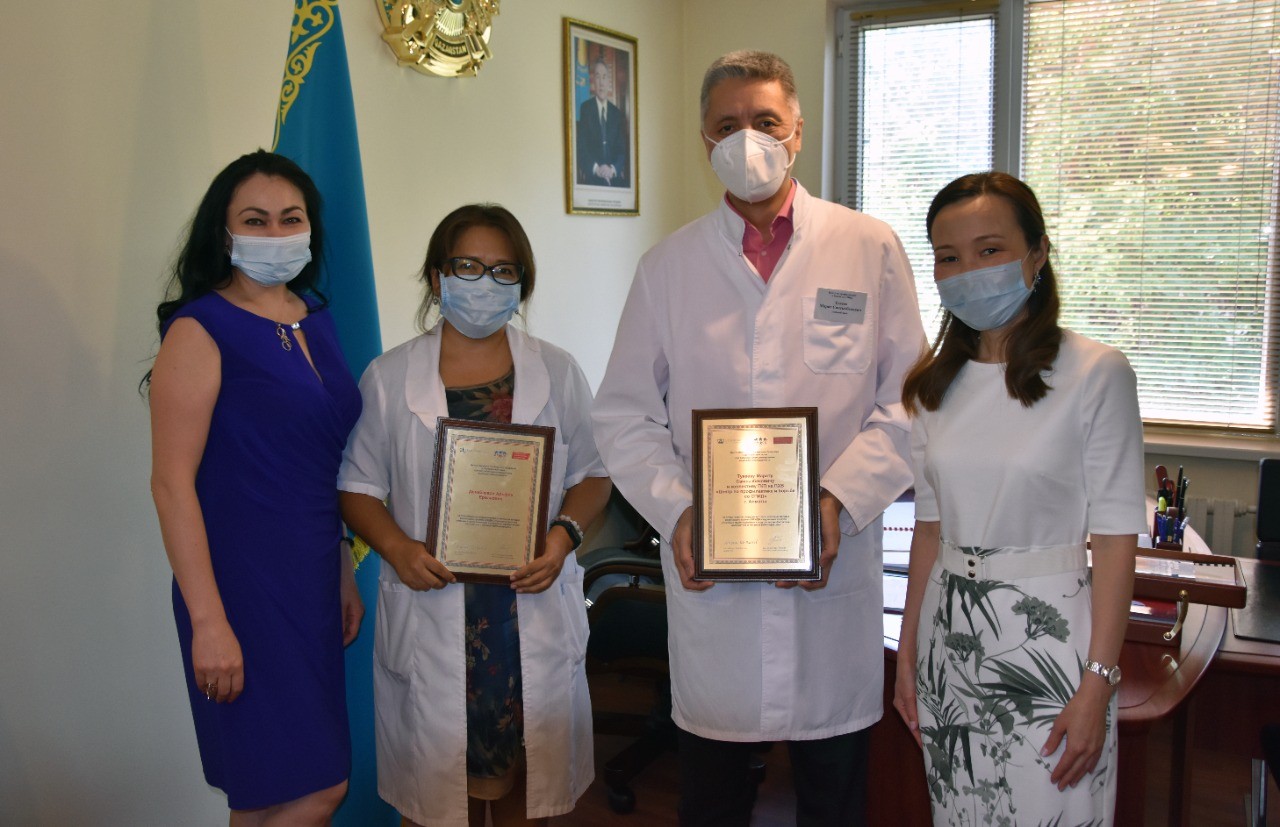 Almaty Center for Prevention and Control of AIDS, Chief Doctor Dr Marat Tukeev and Deputy Chief Dr Alphiya Denebayeva and GHRCCA team. Four masked people standing holding certificates