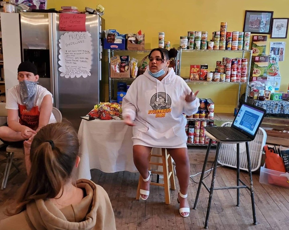 Ayesha Jones, a youth peer leader, here conducts a Naloxone training at the Philmont Free Store. Photo credit: Youth Clubhouse Staff Photo of youth speaking to other youth in a bookstore