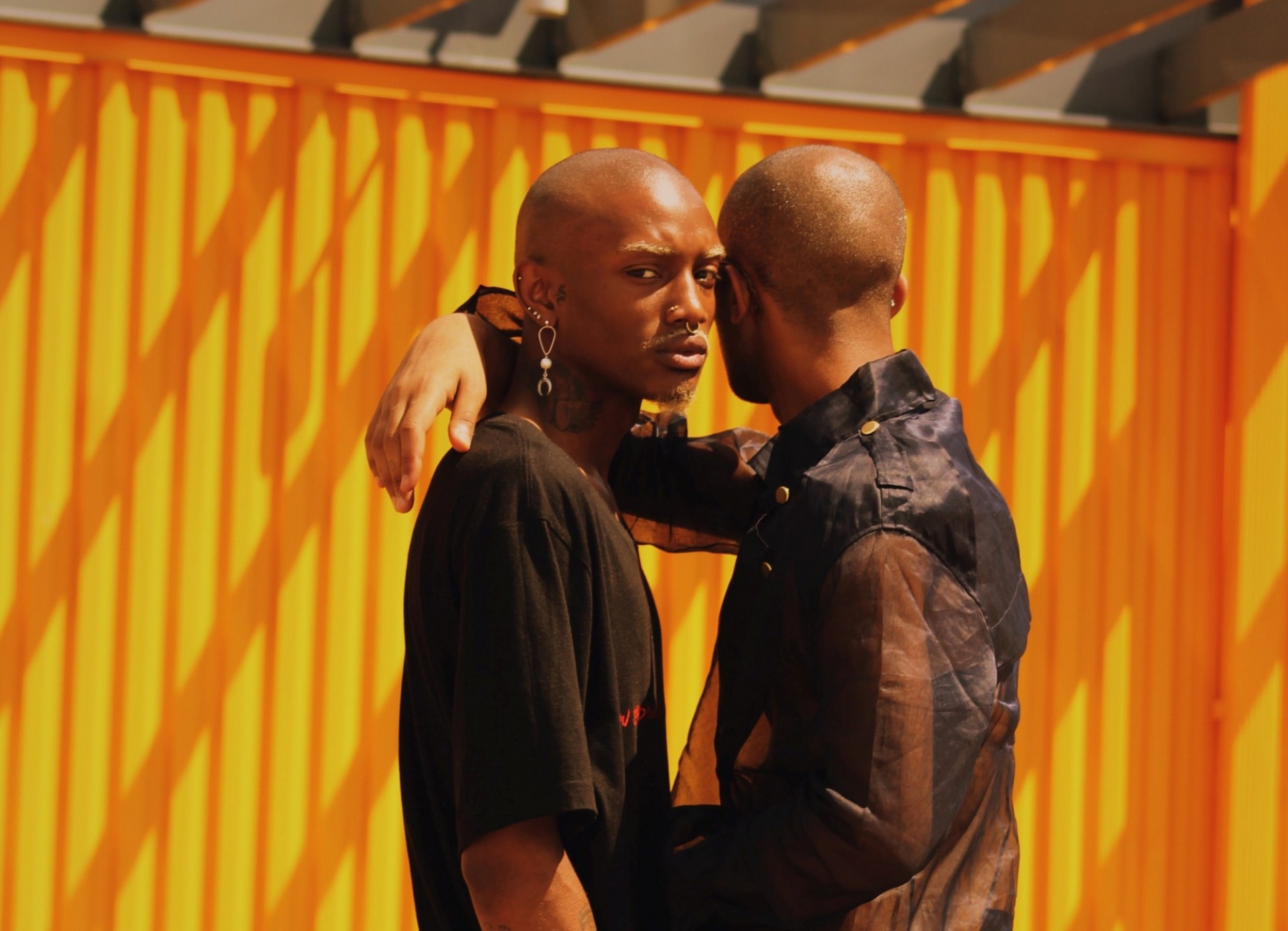 a couple (two Black men) standing and hugging