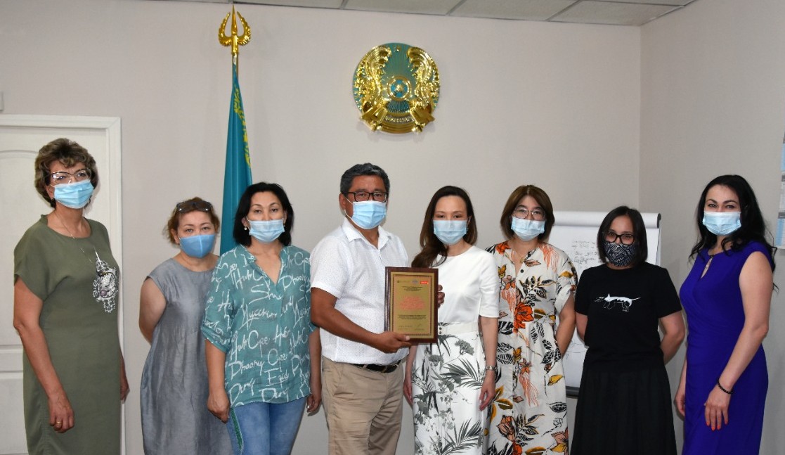 Kazakh Scientific Center of Dermatology and Infectious Diseases, Director Dr. Asylkhan Abishev and team of KSCDID Group of masked people inside holding certificate