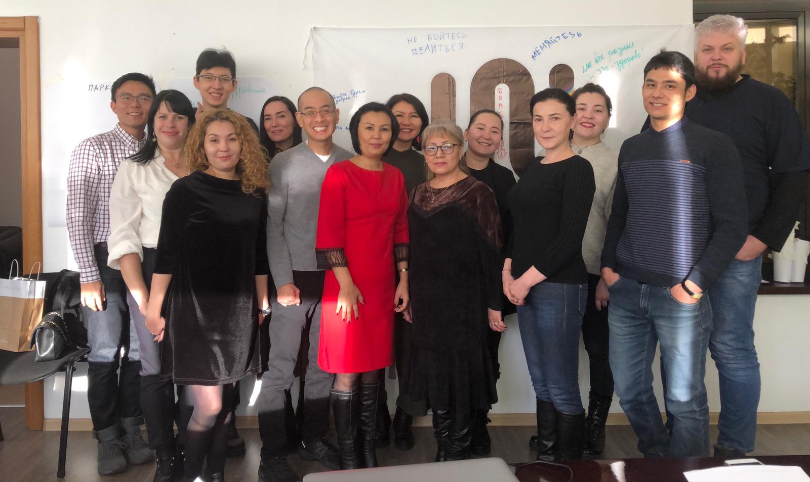 UNI training participants and leadership pose against the UNI logo