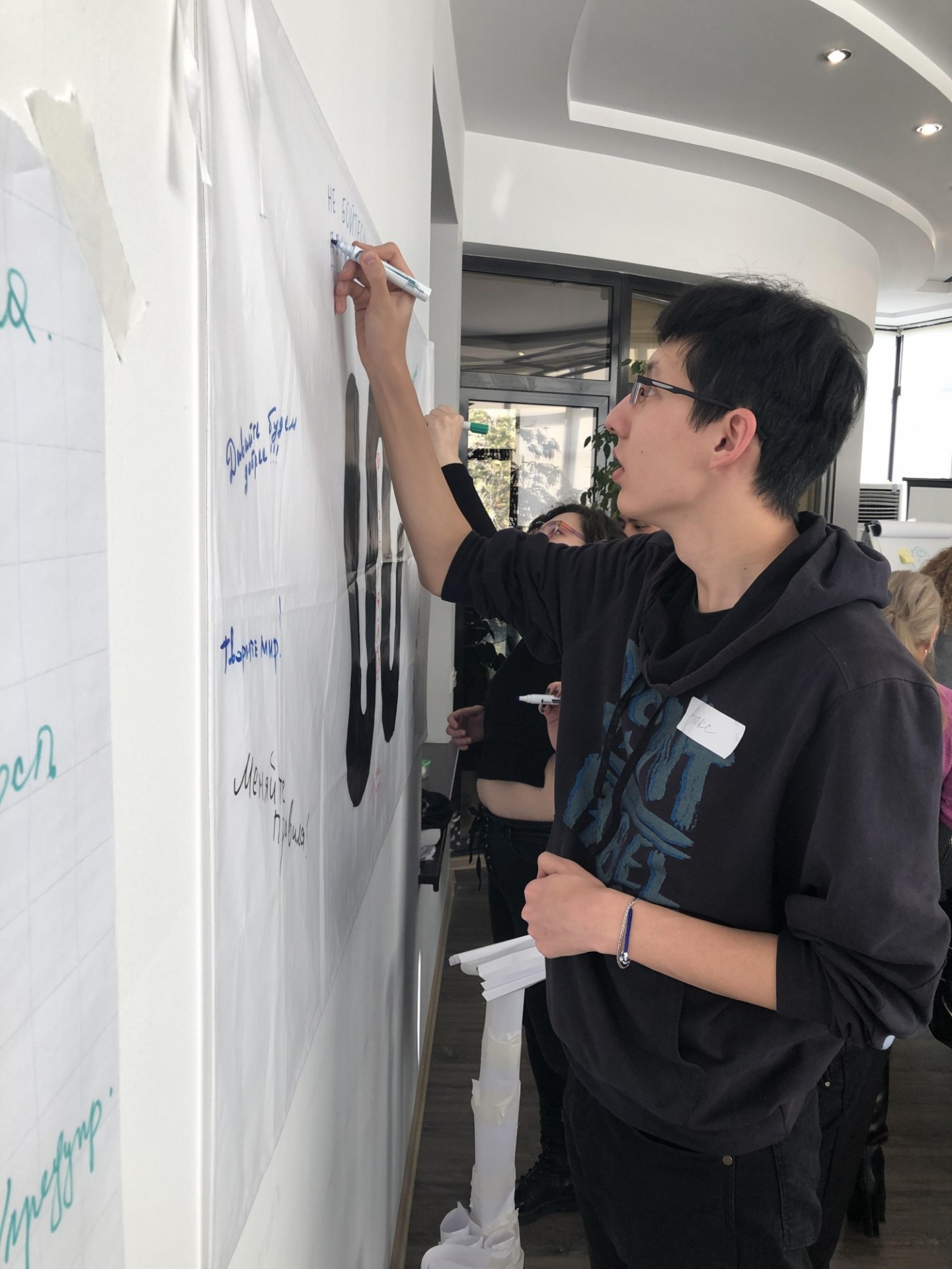 Staff writing an encouraging message on a paper on the wall