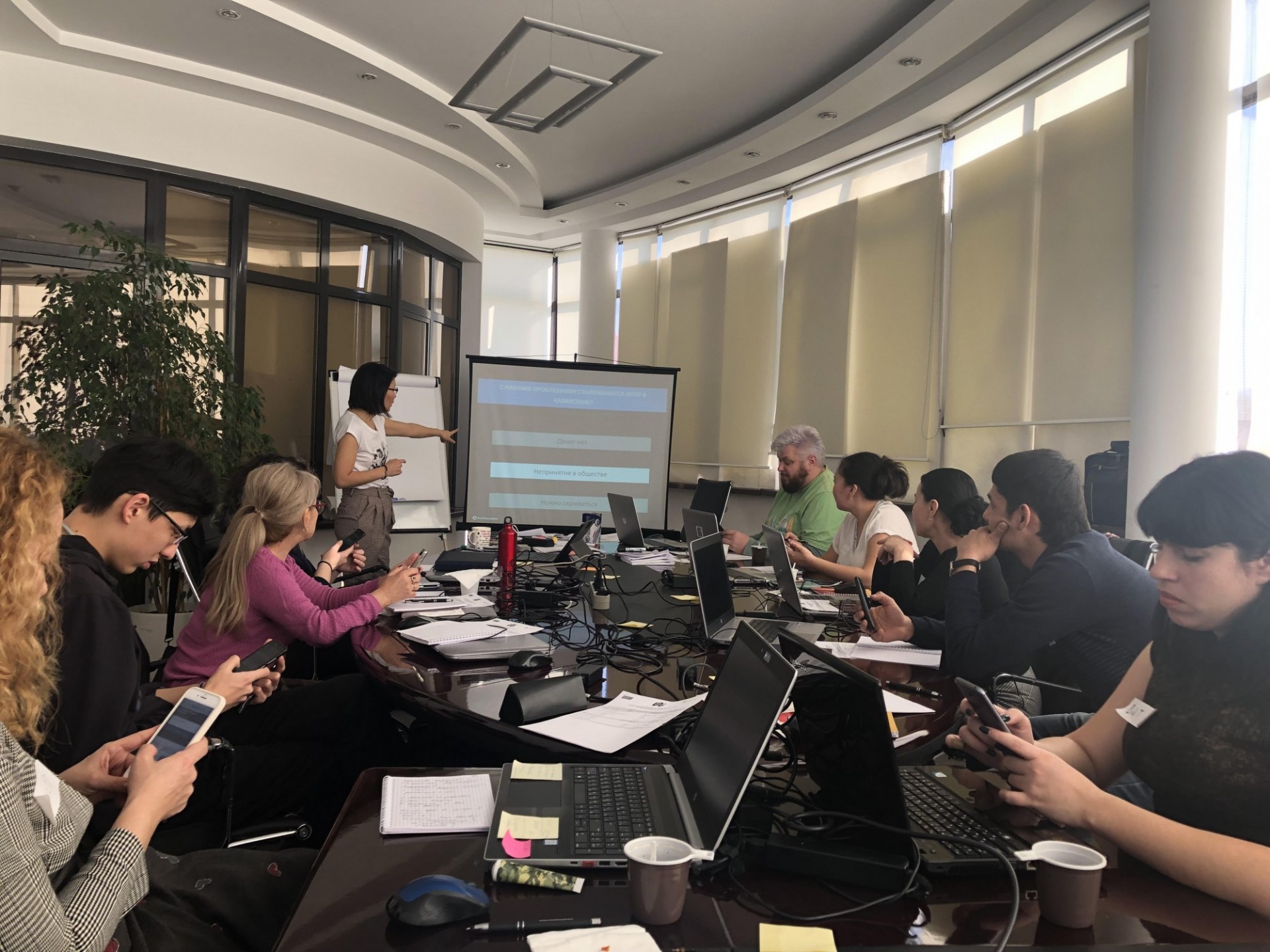 Using Polleverywhere, a live audience engagement tool, to discuss issues facing men from sexual and gender diversity in Kazakhstan Participants around the meeting table use their smartphones to take a poll