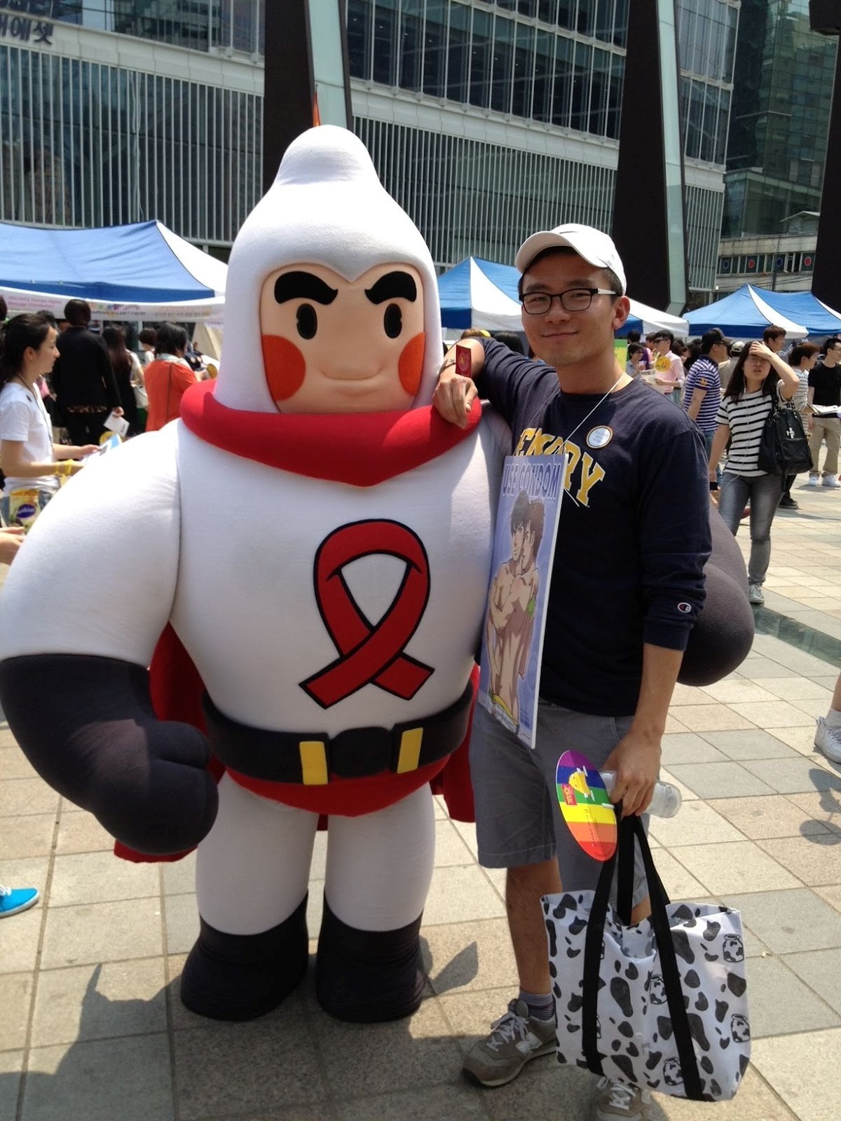 YG and a character bearing a red ribbon, the universal symbol for HIV/AIDS awareness, on the chest and wearing a condom-shaped helmet