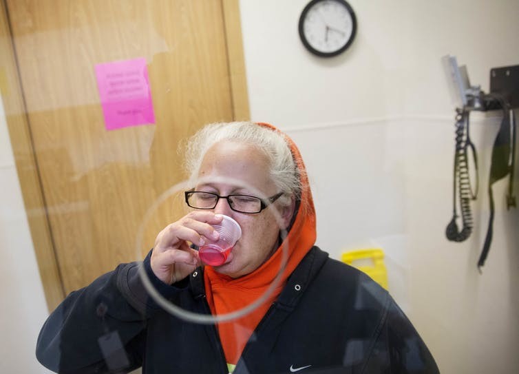From The Conversation: Tarryn Vick takes a dose of methadone at a clinic in Hoquiam, Wash., where she is being treated for drug addiction, June 15, 2017. AP Photo/David Goldman