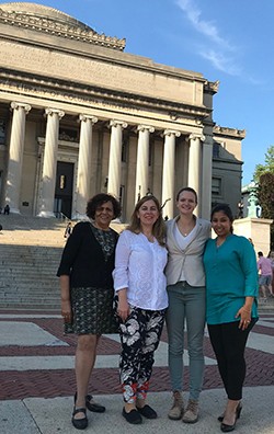 women standing in front of low library