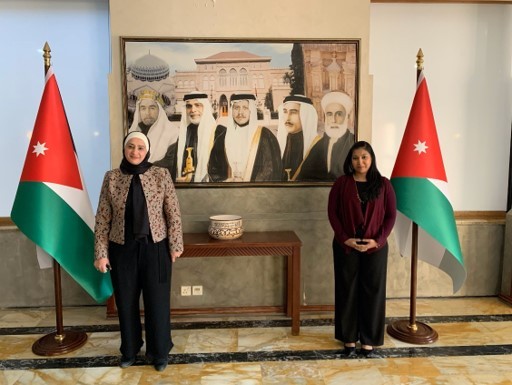 two women in front of a photo and flags in the PM's office