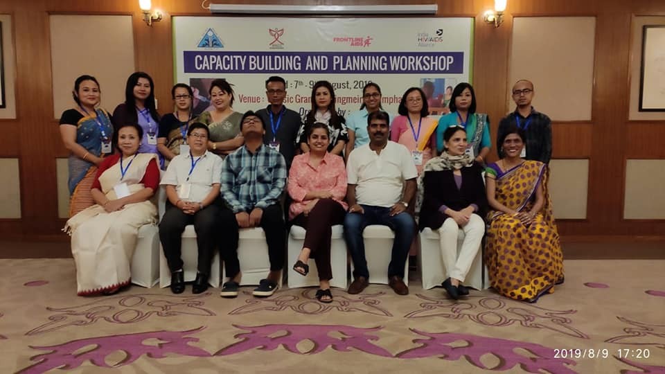 WINGS team in India at a Capacity Building Workshop; Center, Dr. Khosa people standing in front of capacity building workshop sign