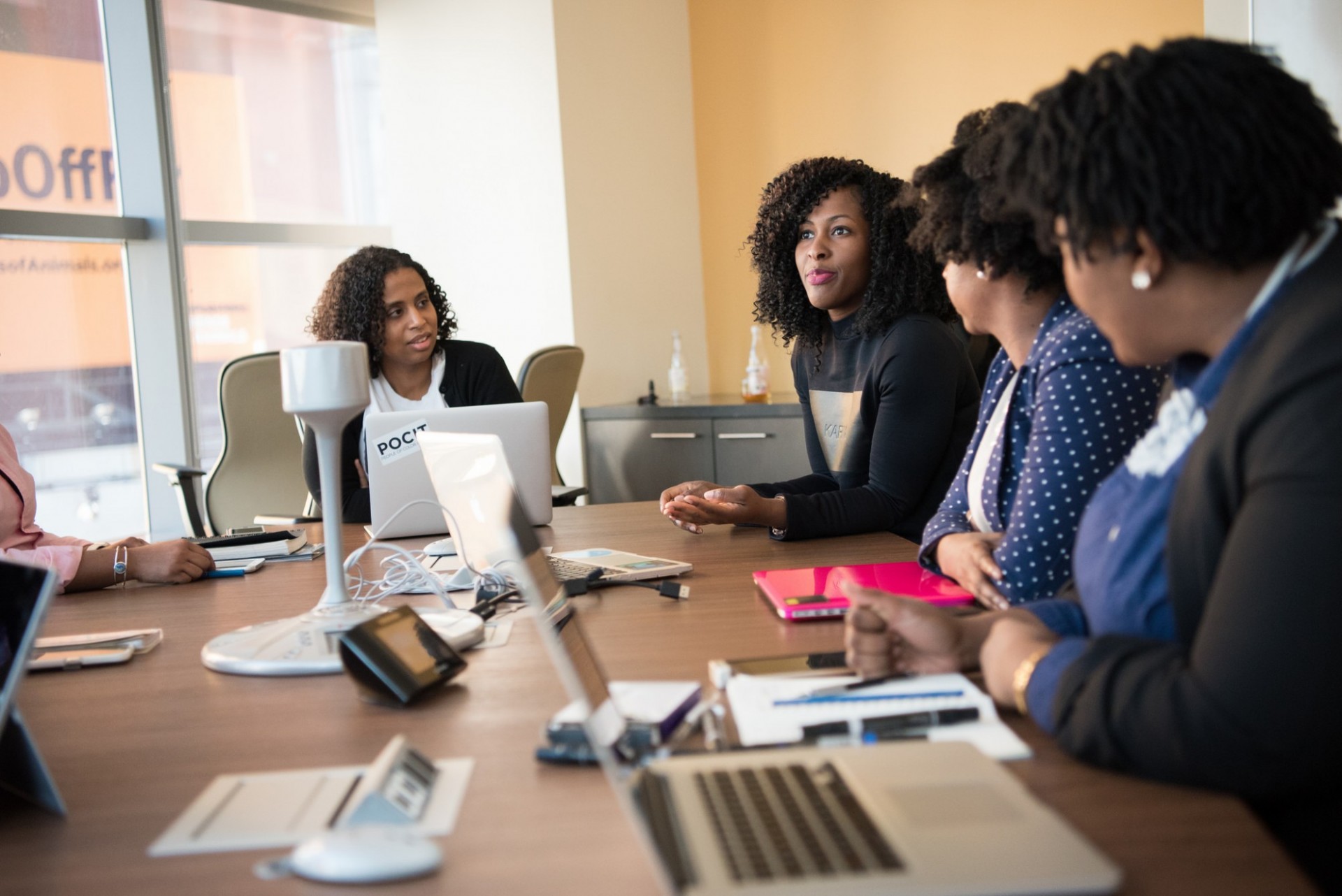 E-WORTH was designed, developed, and delivered by and for black women. Photo credit: WOCintech Black women meeting in a boardroom with laptops