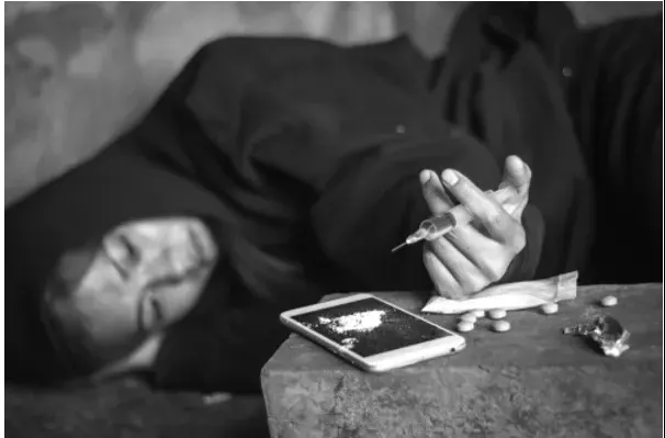 photo of woman laying down about to inject heroin