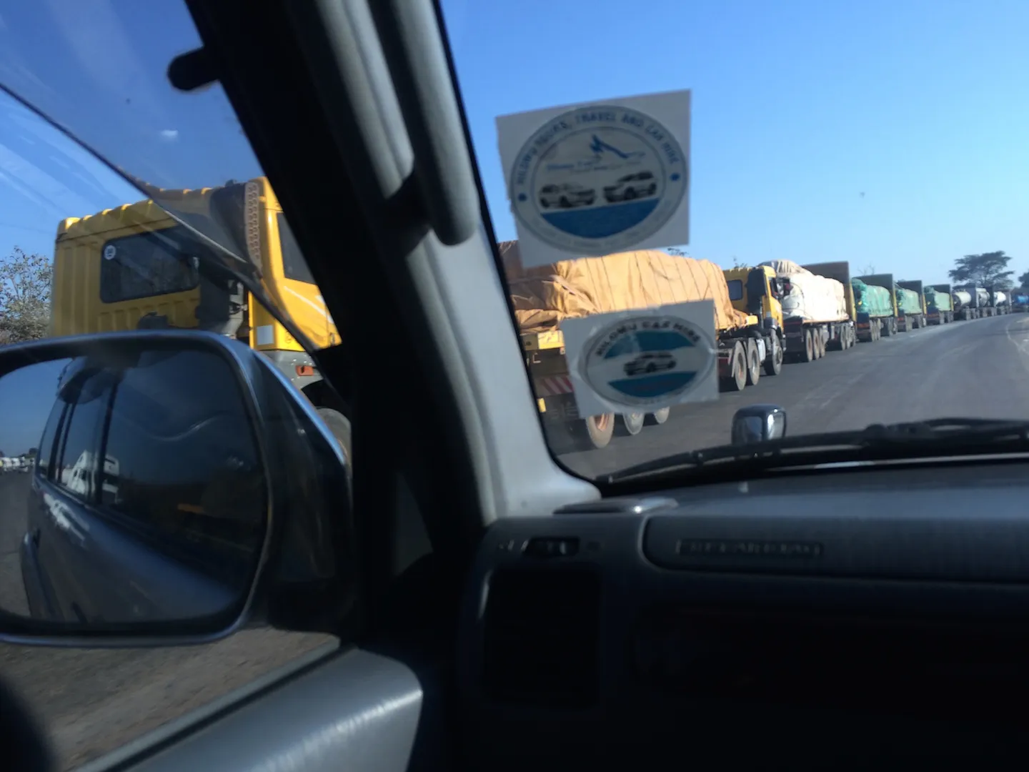 Trucks in line as seen from a car window