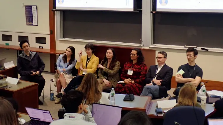 Seven people sitting in a row at the front of a classroom