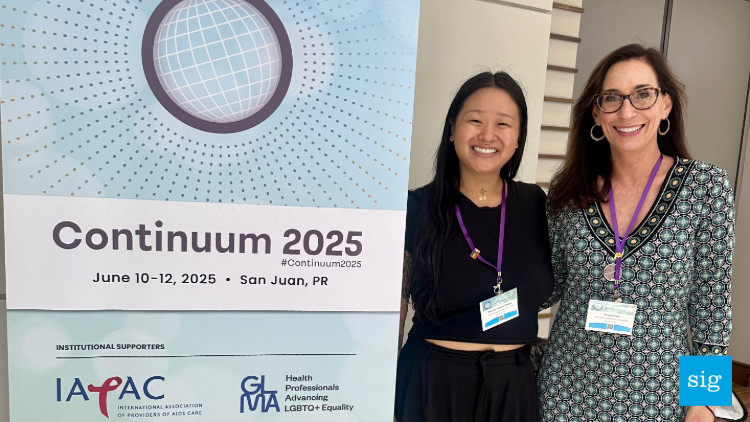 a poster for continuum 2025. Madison Xiaoyao Bogard and Victoria Frye are standing next to it smiling at the camera