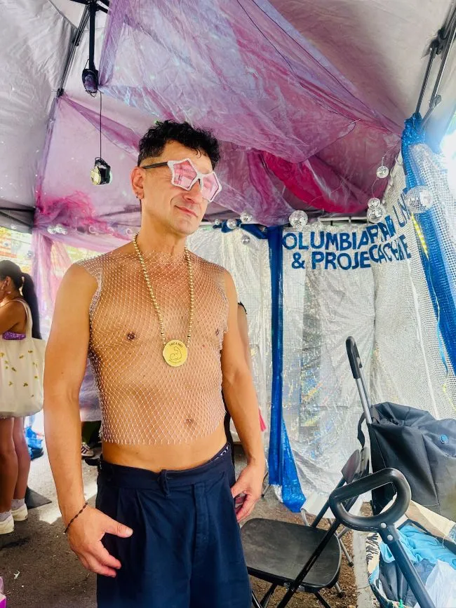 A man wearing star shaped sunglasses and a mesh shirt