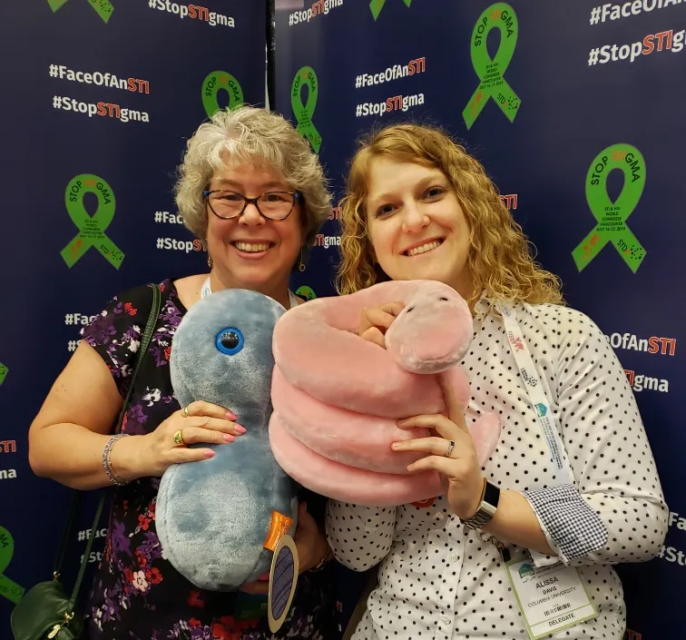 Dr. Alissa Davis pictured holding stuffed animal "STDs"