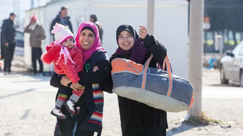 Two Syrian women holding a baby