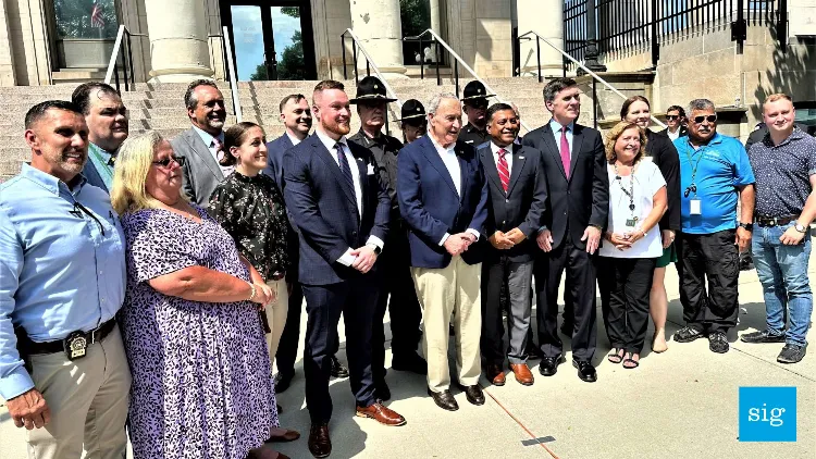 A group of people standing around Senator Chuck Schumer.