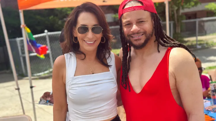 Two people standing outside, Both are wearing tank tops.